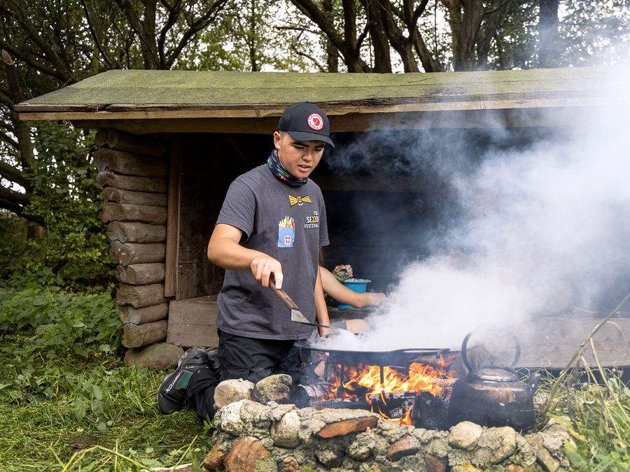 Elev, der er i gang med at lave mad over bål i valgfaget Jord til Bord