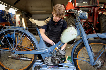 Elev arbejder med en motor i værkstedet på Kongeådalens Efterskole
